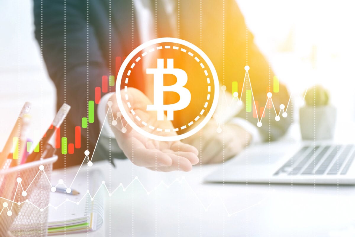 Businessman with virtual bitcoin symbol at table in office